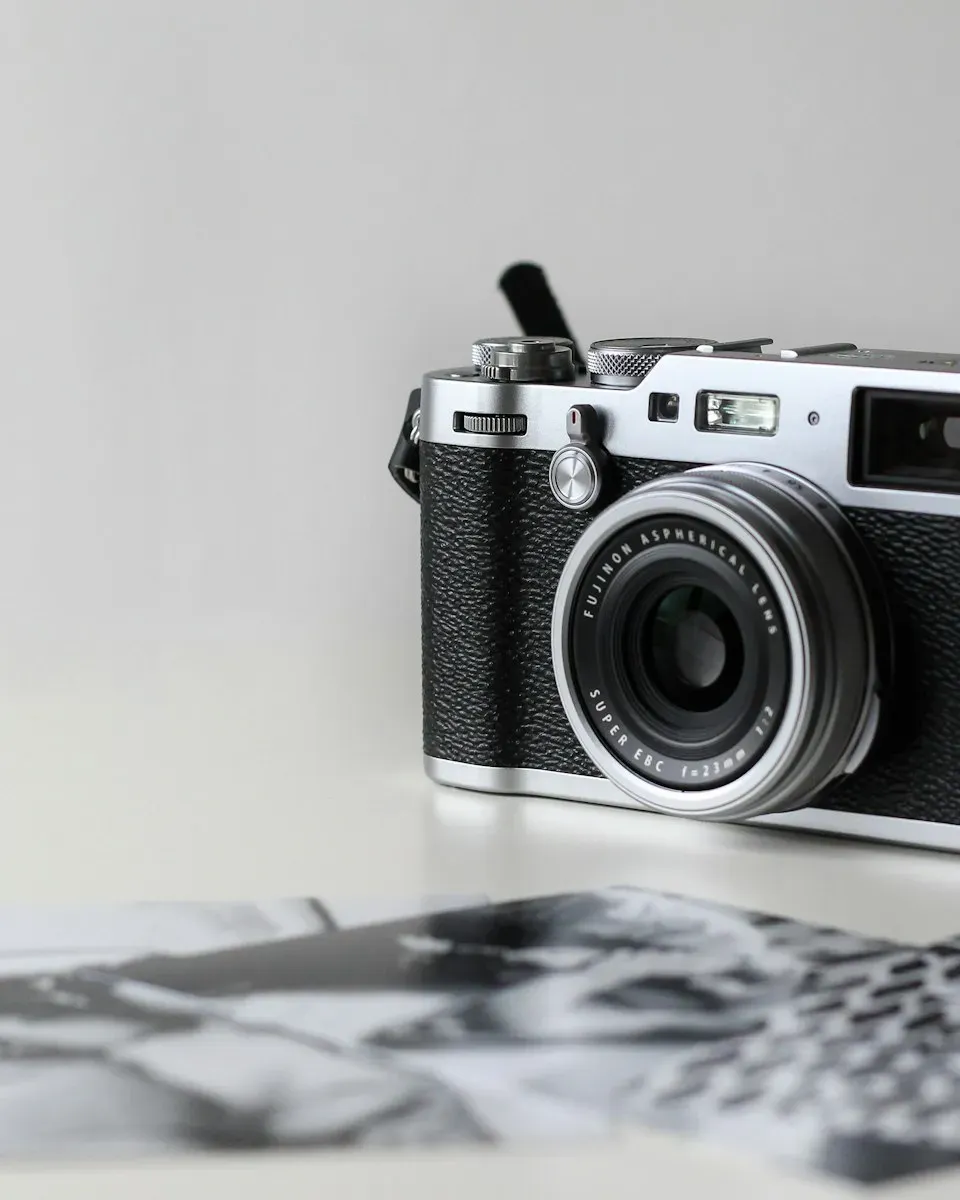 A silver rangefinder-style camera on a white table.